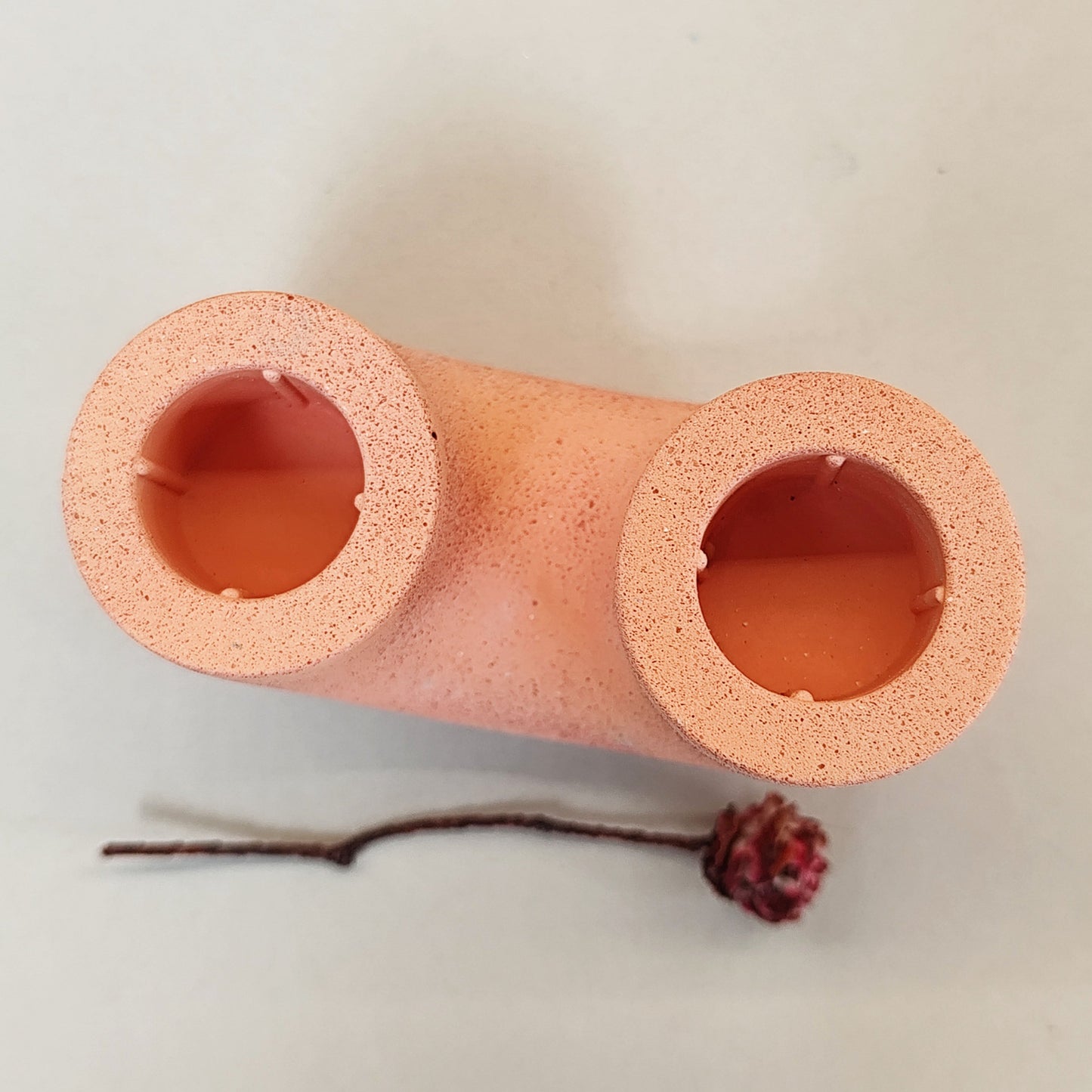 over head photo of handmade duo candle hole with rough texture in a bright orange pop colour