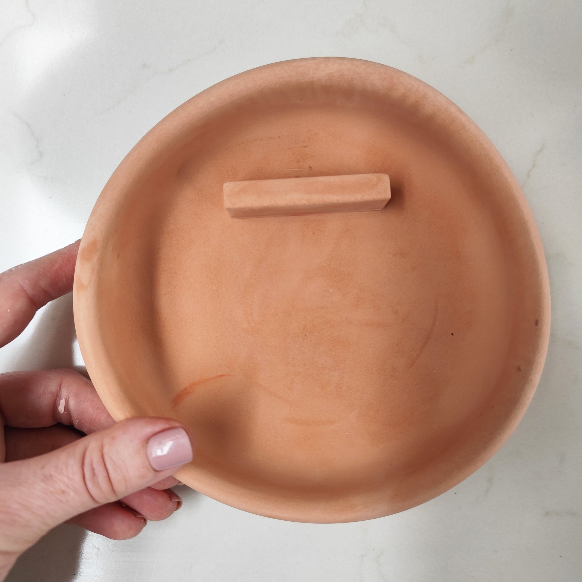 Handcrafted palo santo burner in terracotta show casing the ledge