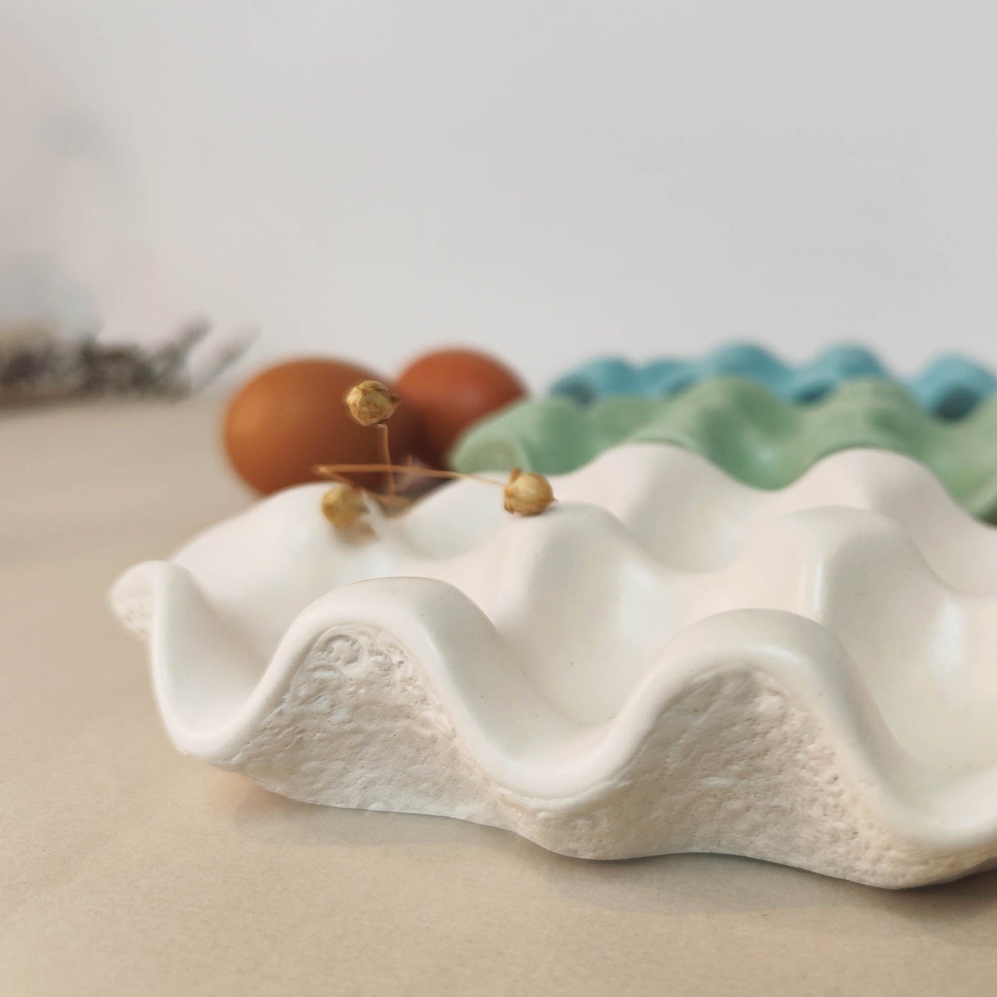 egg tray with dried flower on a neutral background with eggs behind