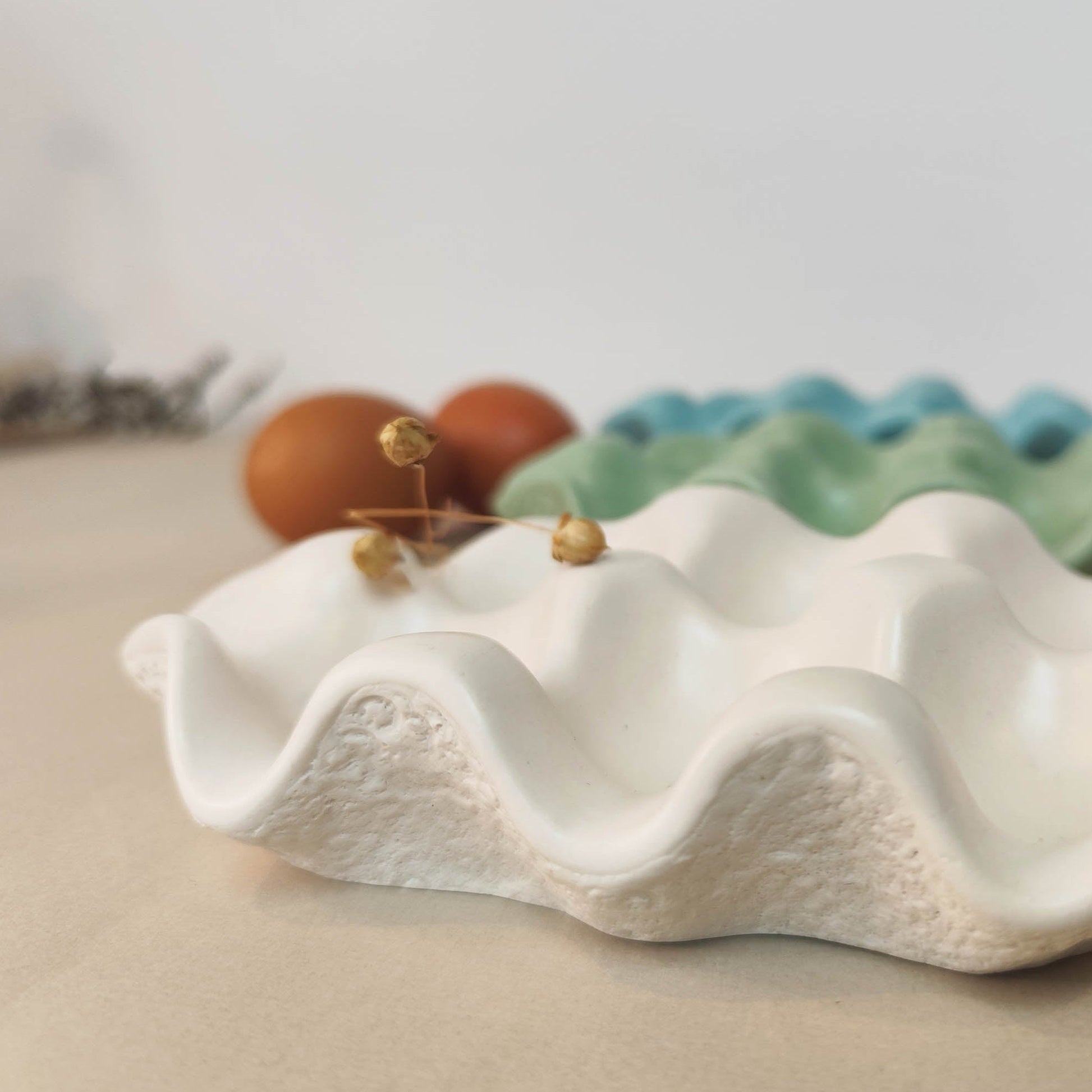 egg tray with dried flower on a neutral background with eggs behind