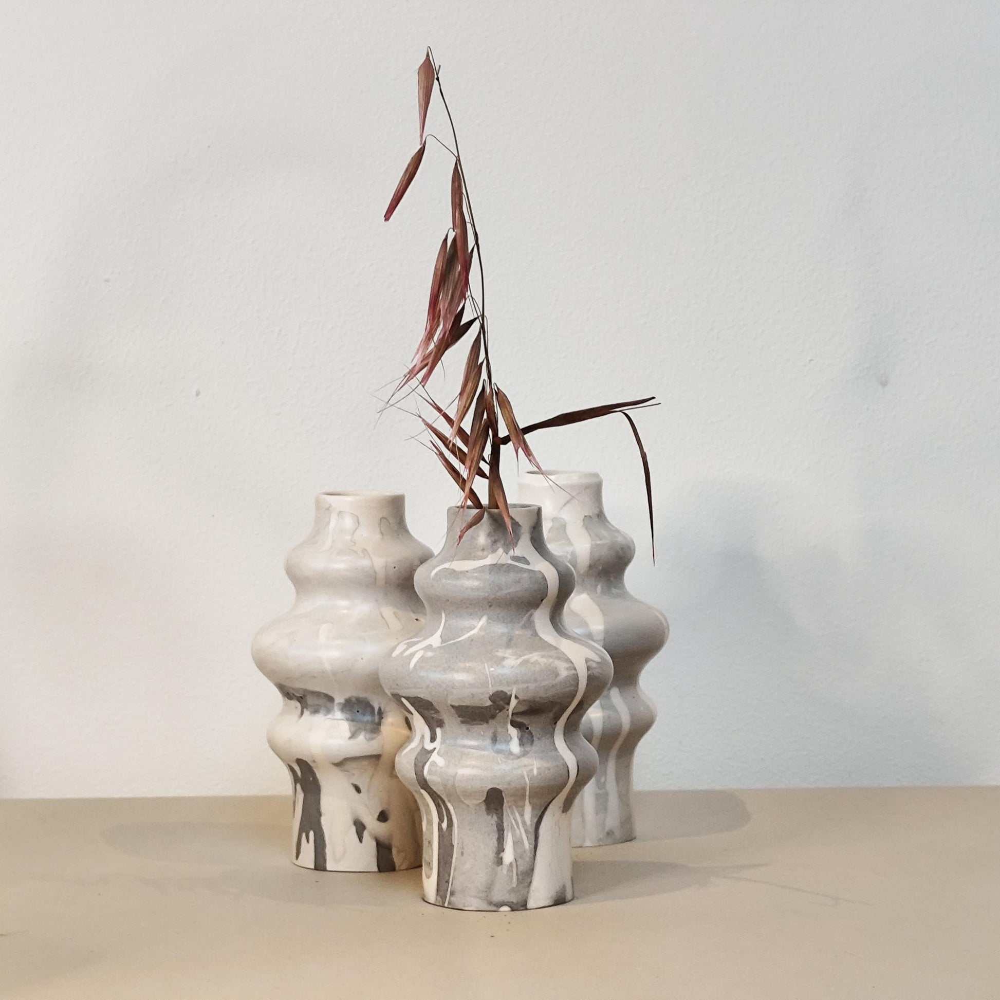 Set of three jesmonite vases with a marble drip design on a neutral background
