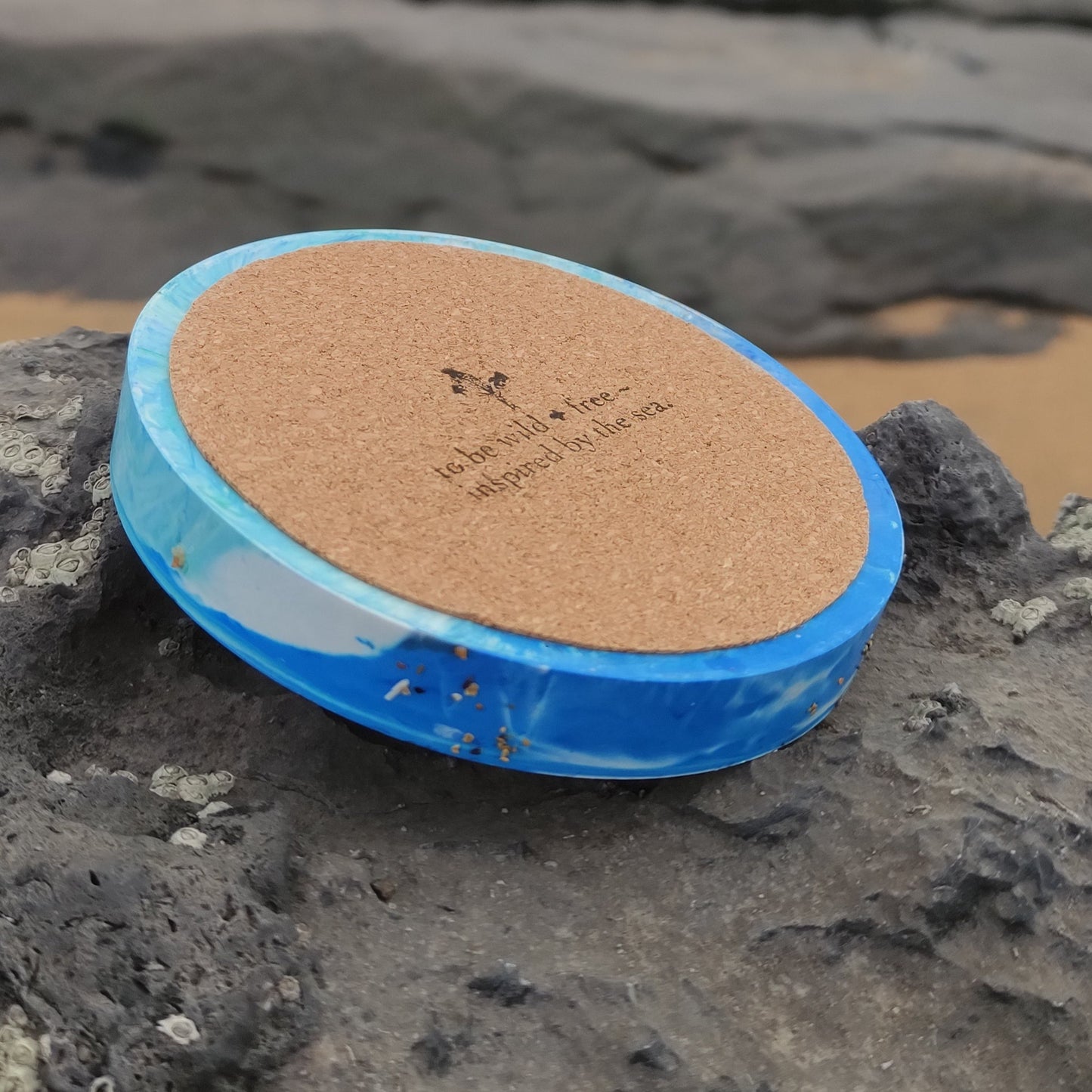 Handmade Jesmonite sea coasters on rock on beach
