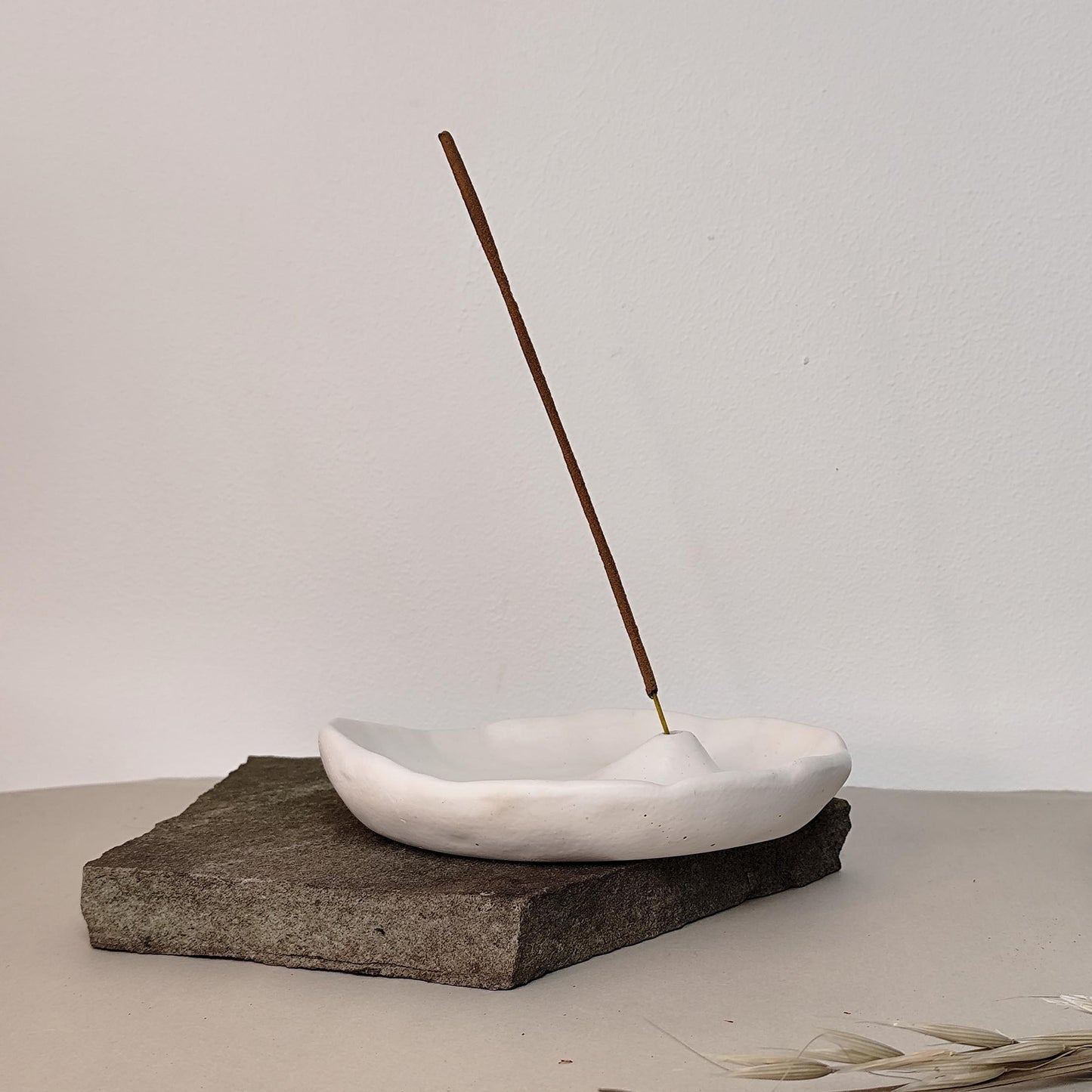 White minimalist handmade incense burner on a rock