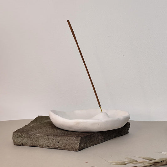 White minimalist handmade incense burner on a rock