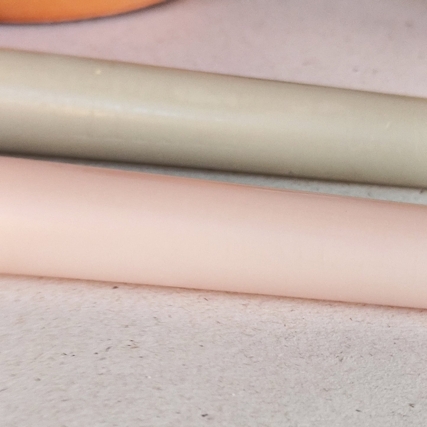 Close up of natural beeswax taper candles showing smooth hand poured texture