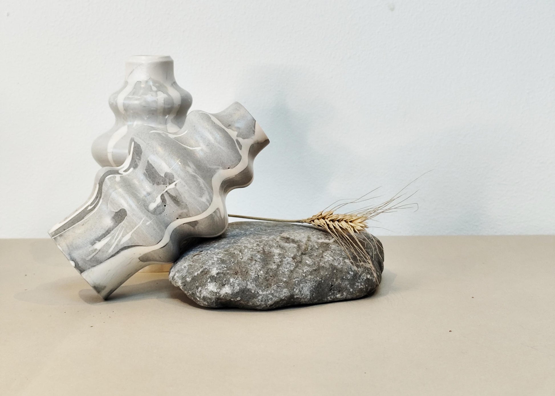 Decorative jesmonite curved vase on a stone with a minimal background
