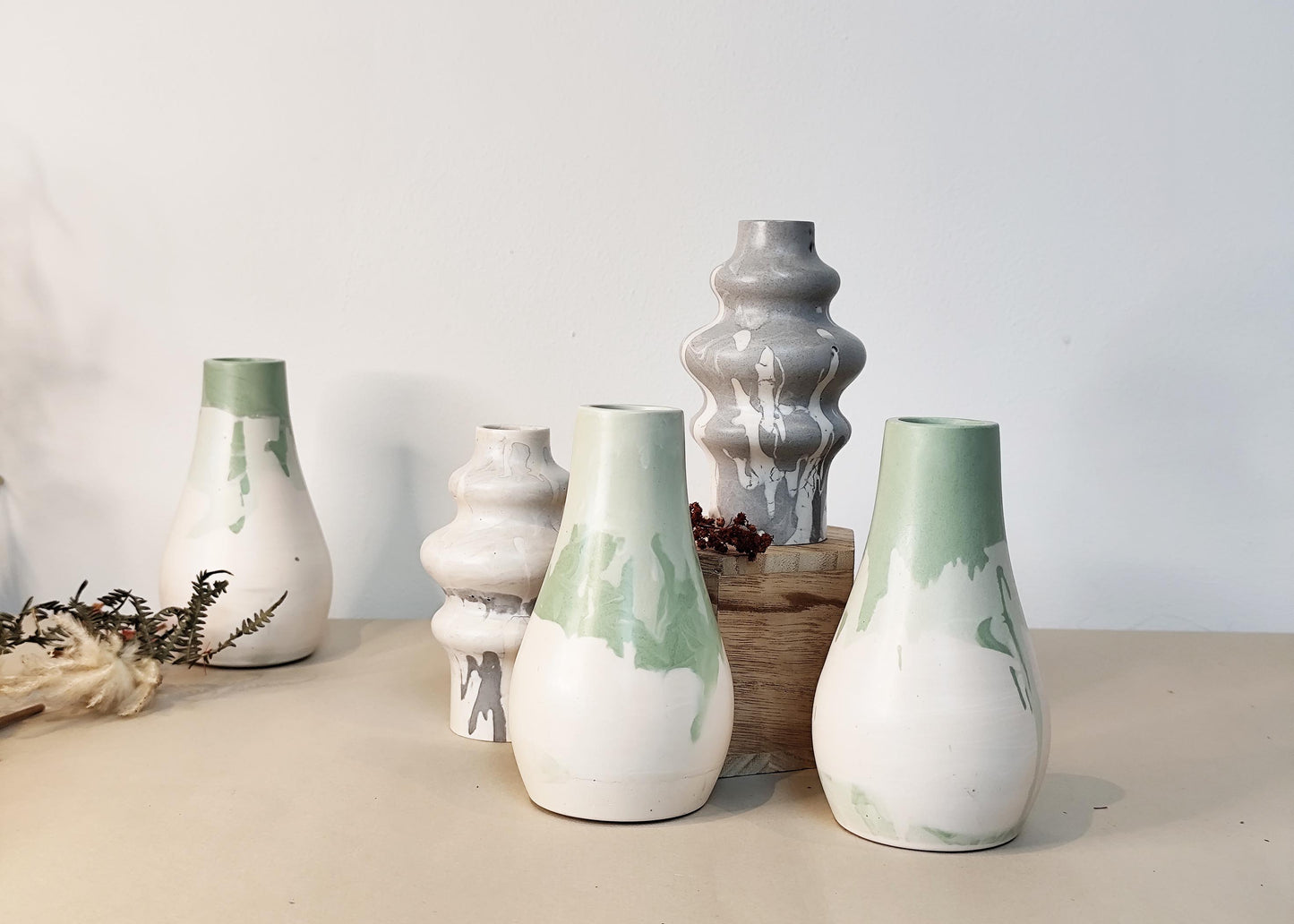Set of handmade dried flower vases with grey, green and white patterns on a neutral background